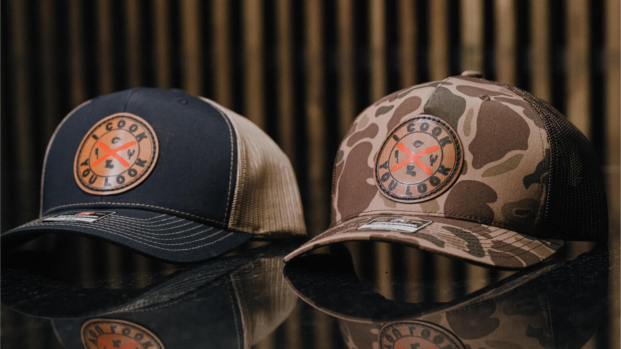 I Cook You Look Richardson 112 trucker hats in navy with tan mesh and brown camo with mesh back, leather patch logo on both.